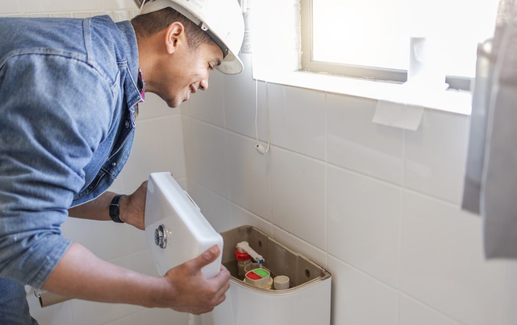 toilet maintenance plumber and man fix cistern home renovation and builder service contractor b